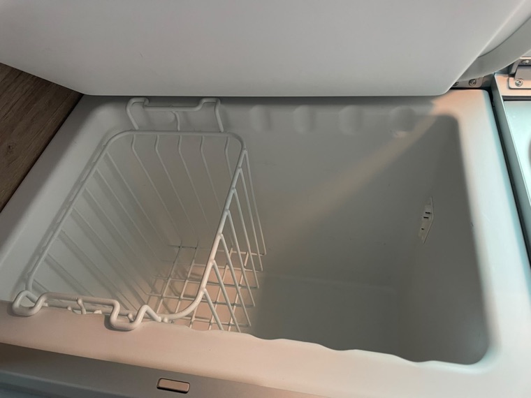 Blick in die geöffnete Kühlbox der Küchenzeile im VW California Coast