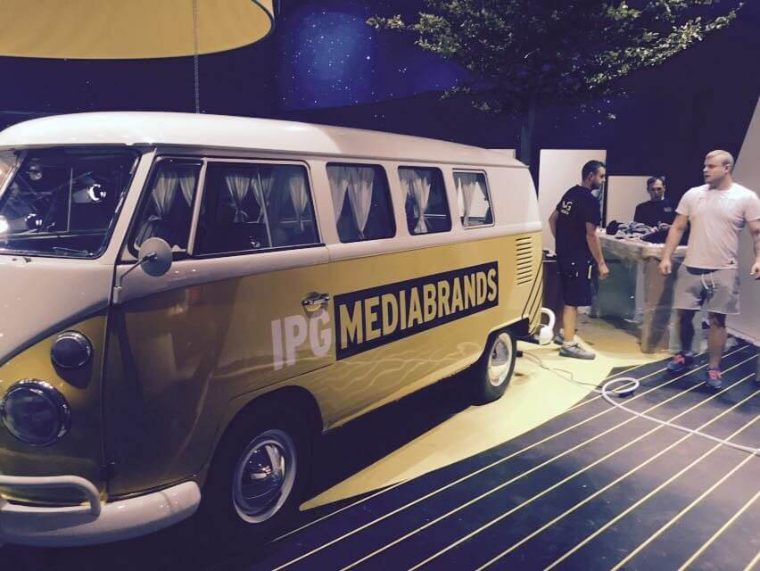Bulli mit goldbrauner IPG-Mediabrands-Folierung bei einem Messeaufbau