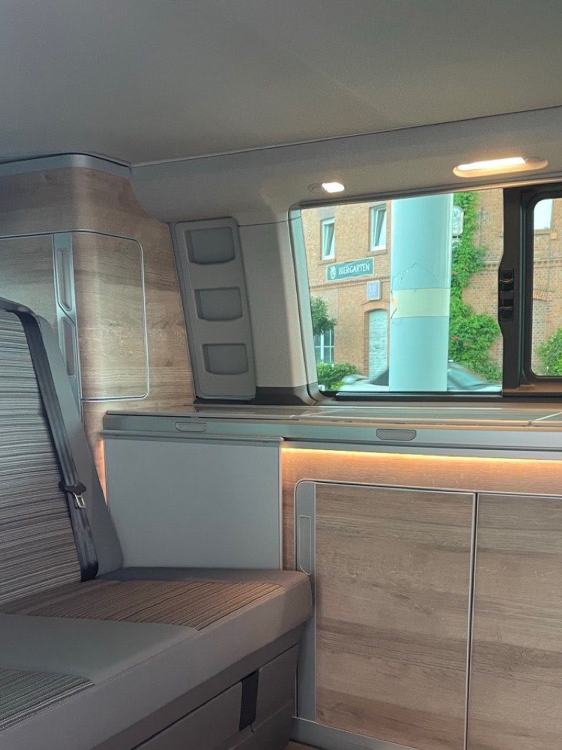 Innenraum des VW California Coast mit Sitzbank, K&uuml;chenblock und Ambientelicht