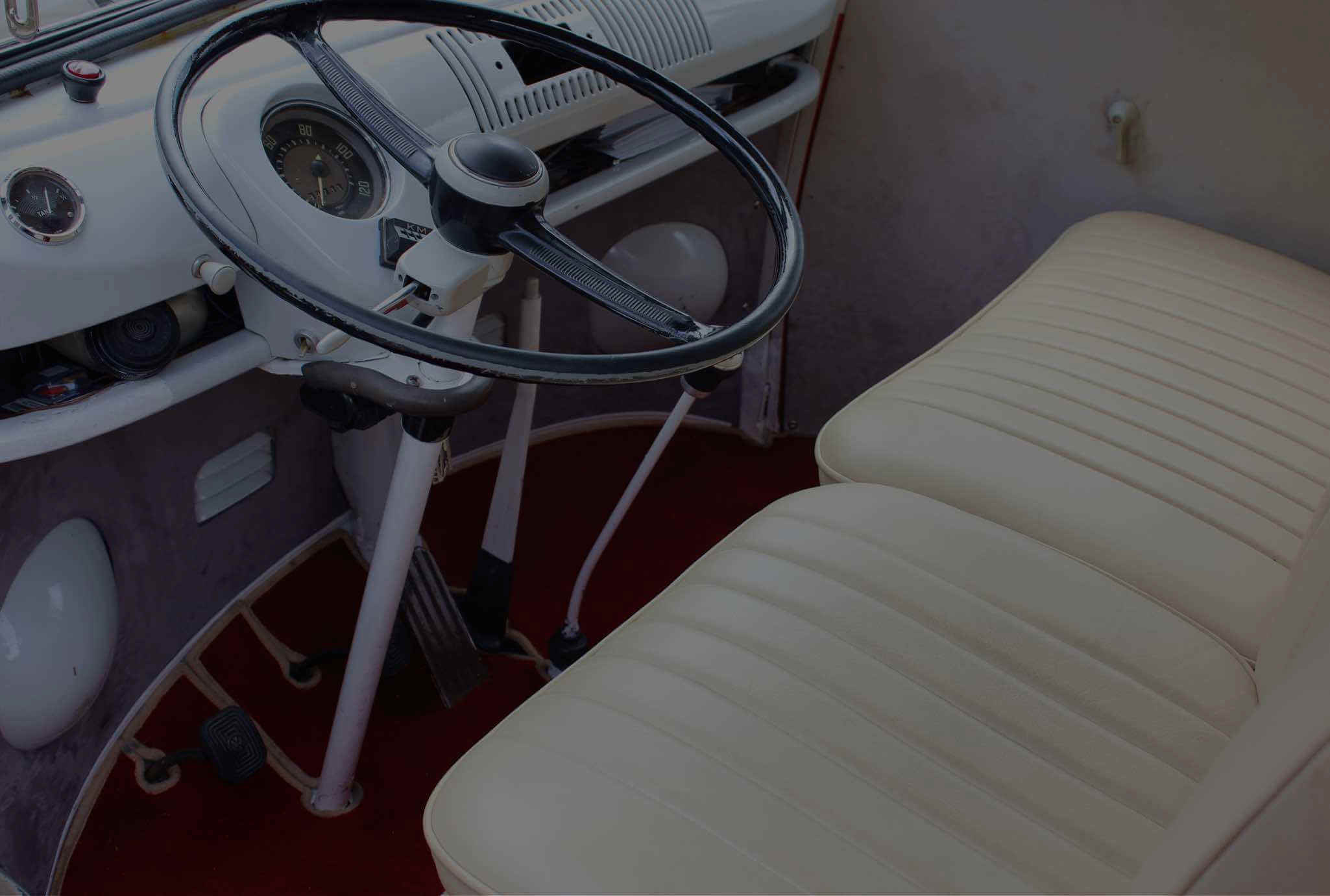 Armaturenbrett mit Tachometer, Lenkrad und rotem Fußraum in einem original restaurierten VW T1