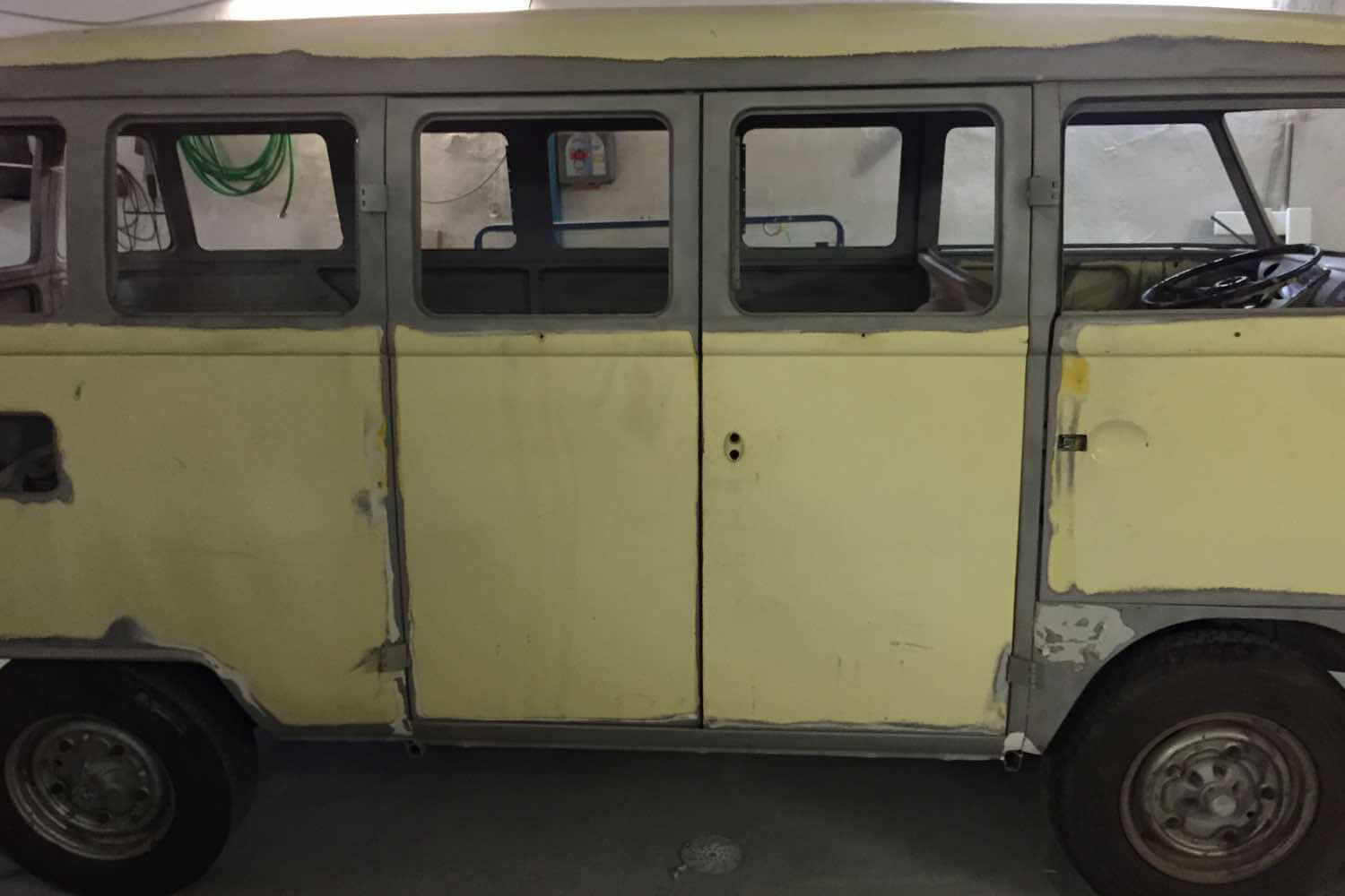 Seitenansicht eines VW T1 Bulli während der Restaurierung, Karosserie in grauer Grundierung ohne Lack