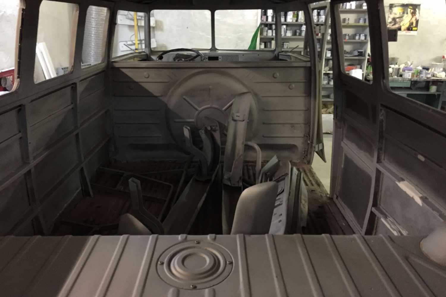 Blick durch den ausgeräumten Innenraum eines VW T1 Rohbaus während der Restaurierung in einer Fachwerkstatt