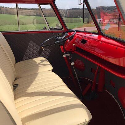 Fahrerkabine eines frisch renovierten VW Bulli T1 von 1964 in rot lackiert und mit Safari-Scheiben