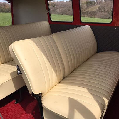 Innenraum eines Bulli T1 mit VW Sitzen und rotem Teppich von 1964
