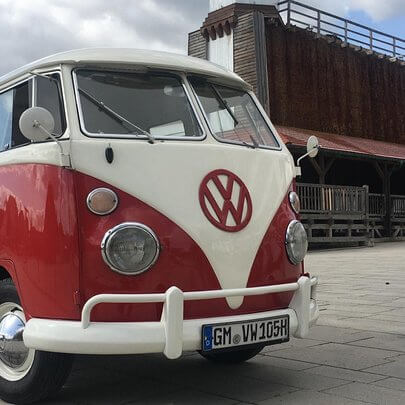 Front eines Oldtimer VW Bulli rot-weiss lackiert und mit Safar-Fenstern