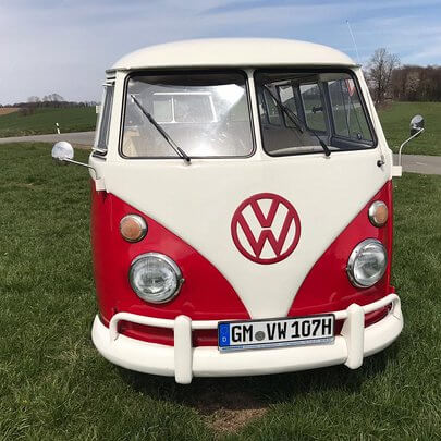 Rot-weiss lackierer Oldtimer Bulli von vorne mit Safari-Doppelscheiben