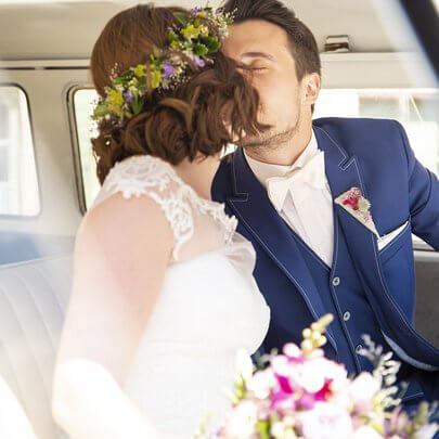 Hochzeitspaar im Hochteitzbulli küssend im Innenraum