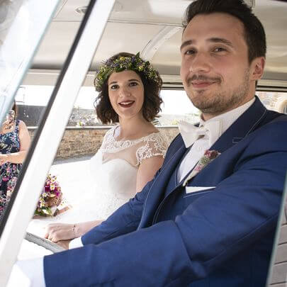 Bräutigam hinter dem Steuer eines gemieteten VW Bulli T1 mit Braut auf dem Beifahrersitz