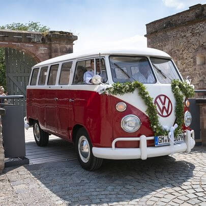 Volkswagen Bulli T1 für die Hochzeit dekoriert auf der Schlosseinfahrt