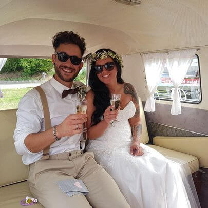 Brautpaar beim Sektempfang im restaurierten VW Bulli 1973